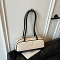 Contrast woven shoulder bag with black leather straps and zip closure on leather sofa - Black