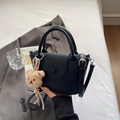 Mini borsa a secchiello in pelle litchi nera con manico e ciondolo a orsetto - Nero