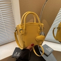 Sac seau jaune en cuir grainé avec pendentif en forme de cœur et bandoulière longue - Jaune