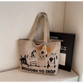 Dettaglio della borsa tote in tela con stampa cartoon e portachiavi a forma di cane - Cachi