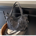 Dettaglio della borsa tote in denim grigio scuro lavato con tasche a zip e frange - Nero