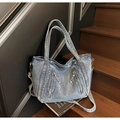 Vista dettagliata di una borsa tote in denim blu con cerniere su una scala di legno - Azzurro