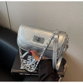 Detailed macro view of silver quilted leather finish and metallic turn-lock closure - Silver