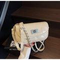 Close-up of cream quilted crossbody bag featuring silver turn-lock and chain strap detail - Khaki