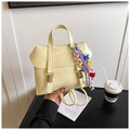 Detail of a creamy yellow faux leather backpack with colorful charms and double strap - With Charm Style / Yellow