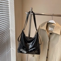 Sac hobo noir brillant avec chaînes métalliques et doubles poches dans un dressing - Noir sans Pendentif