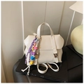 Minimalist cream white PU leather backpack with colorful beaded tassel on a black book - With Charm Style / White