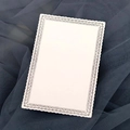 Macro view of laser cut lace border detail on white matte card for weddings - Ivory