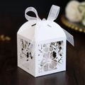 Detail einer weißen lasergeschnittenen Gastgeschenkbox mit Blumenmuster und Schleife - Weiß