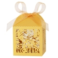 Close-up of golden laser-cut gift box with tropical leaf patterns and ribbon bow - Gold