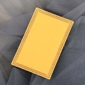 Bright yellow rectangular card with laser-cut lace edges on dark grey mesh background - Gold