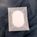 White laser cut lace paper card with floral rose corners on a blue mesh background - Ivory
