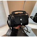 Detalle de bolso de charol negro con hebilla de metal plateado y correa ajustable - Negro
