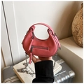 Dettaglio borsa rosa in pelle martellata con catena d'argento e manico curvo - Rosa