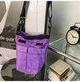 Detail of a purple nylon crossbody bag featuring double front pockets and black straps - Purple