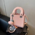 Pink lychee texture leather handbag with silver eyelets and heart pendant accessory - Pink