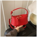 Detailansicht der roten Handtasche aus Narbenleder mit goldenem Drehverschluss und Griff - Rot