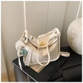 Detail einer weißen Umhängetasche aus Leder mit goldener Schließe und Spitzenanhänger - Beige Mit Anhänger