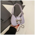 Détail du sac lavande avec grand nœud en métal doré et bandoulière en chaîne élégante - Violet