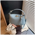 Detail der hellblauen Handtasche mit Litschimuster-Leder und goldenem Drehverschluss - Blau