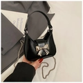 Detailed view of black mini handbag featuring a large silver bow and metallic chain strap - Black