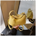 Detail der gelben Tasche mit Litschimuster, goldenem Drehverschluss und Spiegelreflexion - Gelb