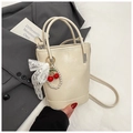 Détail du sac seau crème avec pendentif cerise et perle et nœud en dentelle blanche - Avec Pendentif / Blanc