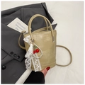 Détail du sac seau beige avec nœud en dentelle et pendentif cerise et perles - Avec Pendentif / Kaki