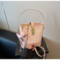 Detailed view of pink bucket bag with monogram pattern, gold lock, and puppy charm - Pink (With Pendant)