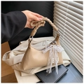 Beige hobo bag with braided handle, lace bow, and pearl charm detail shown in hand - Khaki (With Pendant)