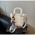 Detailansicht der weißen PU-Leder Eimertasche mit süßem Anhänger und schmalem Gurt - Cremeweiß Mit Anhänger