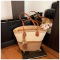 Primer plano de bolso tote de paja con asas de cuero y adorno de conejo de peluche - Con Colgante / Caqui