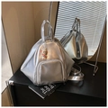 Détail d'un sac à dos triangulaire argenté avec fini métallique et breloque lapin mignonne - Argenté