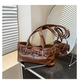 Detailansicht der glänzenden braunen Achseltasche mit dekorativen Schnallen und Ringen - Braun