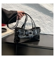 Detail der glänzenden schwarzen Schultertasche mit Silberschnalle und flachem Design - Schwarz