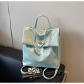 Detalle de mochila verde menta con relieve de cocodrilo, cierre giratorio plateado y asa - Azul