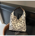 Detalle del bolso tote con estampado de leopardo y correa de cuero en un ambiente de moda - Bolso Hobo de Gran Capacidad / Estampado de Vaca Pequeño