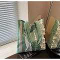 Close-up of green checkered tote bag featuring delicate white lace trim and canvas texture - Green