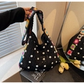 Detailed shot of black woven tote bag with pearl accents and floral bohemian strap - Black