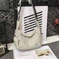 Detail der beigen Nylon-Tasche mit Fokus auf Materialstruktur und gewebtem Tragegurt - Weiß