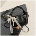 Black pleated bucket bag with twisted handle and pearl bow charm on grey blazer - Black with Pendant