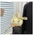 Detalle del mini bolso bowling amarillo crema con asas de bolas y correa de hombro ajustable - Amarillo