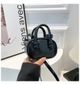 Detalle de mini bolso de cuero negro brillante con asas redondas elegantes - Negro