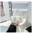 Close-up van een witte mini halfronde handtas met pareldetails op het handvat en riem - Wit