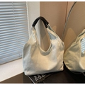 Minimalist cream canvas tote bag with black leather handles in a modern indoor setting - Light Blue