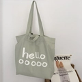 Lichtgroene canvas shopper met minimalistische witte hello-print en handvatten - Cyaan