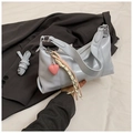Detail of light blue glossy leather bag with pink heart charm and woven strap accents - With Pendant / Blue