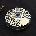 Macro detail of laser-cut gold wedding place cards for wine glasses on wood background - Jewelry Cream Star