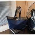Detail of blue canvas tote bag with black leather handles and front decorative zipper - Dark Blue