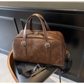 Retro dark brown PU leather handbag with wide nylon strap and silver hardware on a chair - Coffee